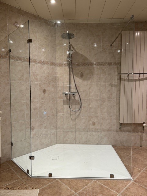 Solid surface douchevloer in beige badkamer met tegelwand