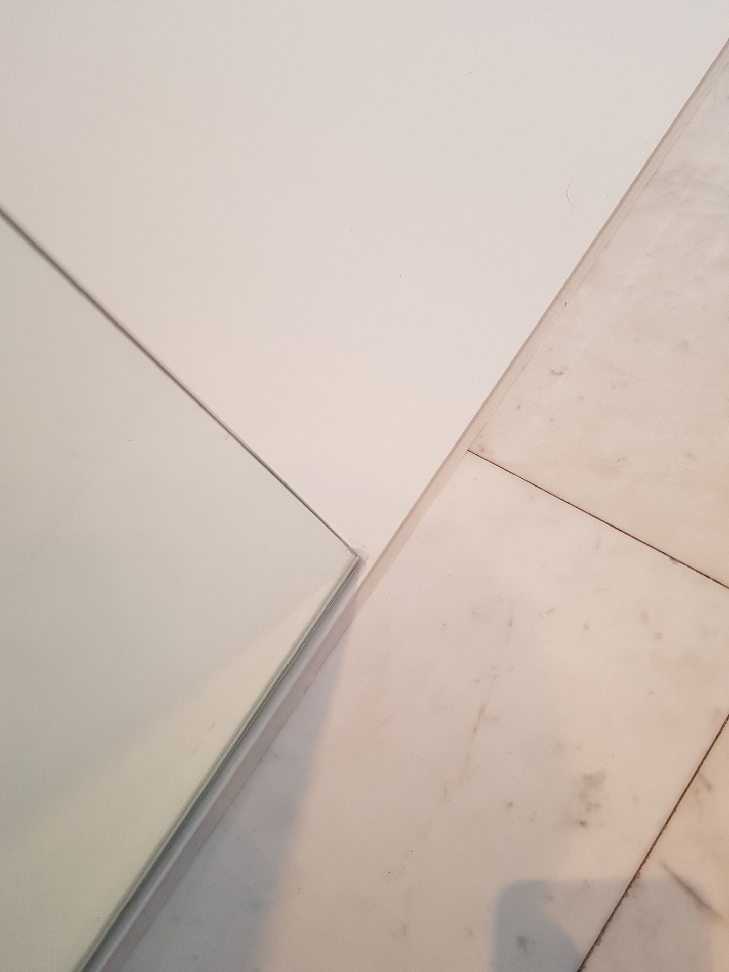 Detailfoto van naadloze aansluiting tussen solid surface vloer en tegelwand